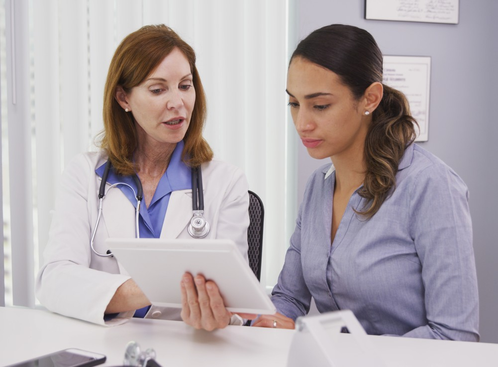 A doctor reviewing results with a patient on a tablet